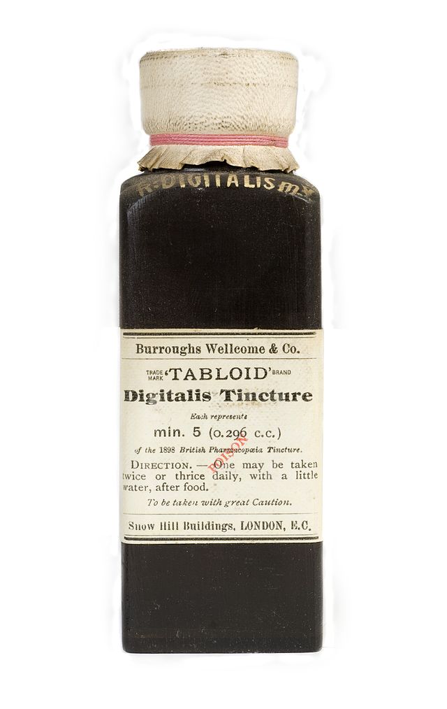 A black glass bottle with an old paper cap and label reading... "Burroughs Wellcome & Co. Digitalis Tincture. Each represente, min. 5 (0.296 c.c.). Direction. — One may be taken twice or thrice daily, with a little water, after food. To be taken with great Caution. Snow Hill Buildings, LONDON, E.C."