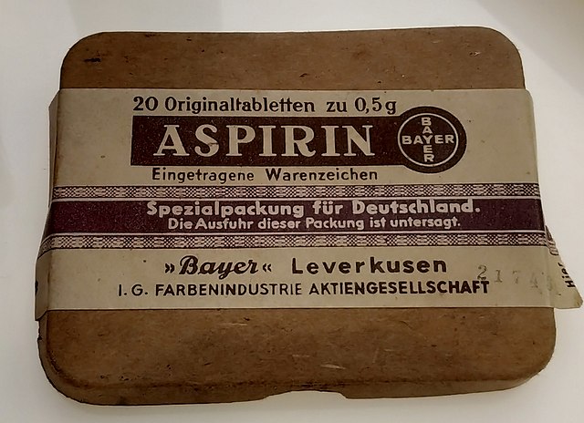 An old brown Aspirin box with a paper label with german text and Bayer branding.