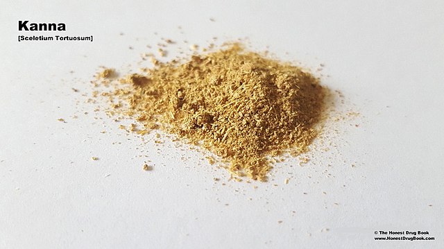 A small pile of gold coloured powder on a white surface.